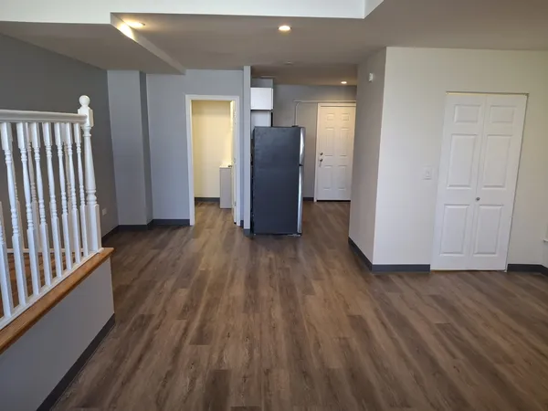 a view of a hallway with wooden floor and stairs