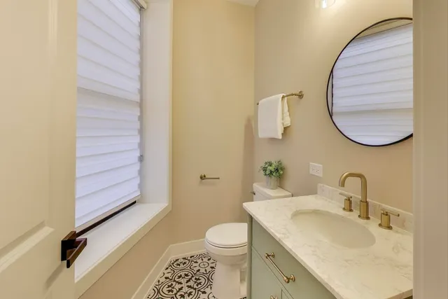 a bathroom with a granite countertop sink toilet and a mirror