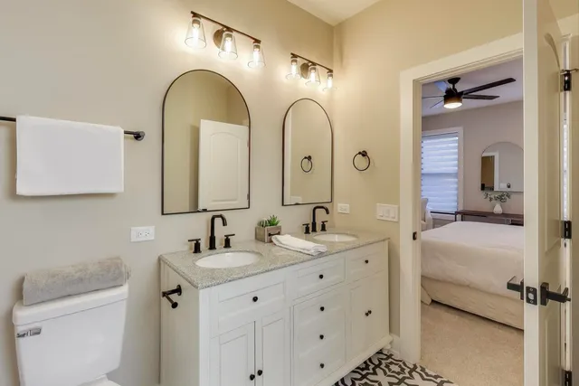 a bathroom with a double vanity sink and mirror with bathtub