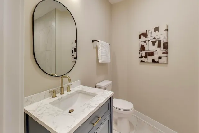 a bathroom with a sink a toilet and a mirror