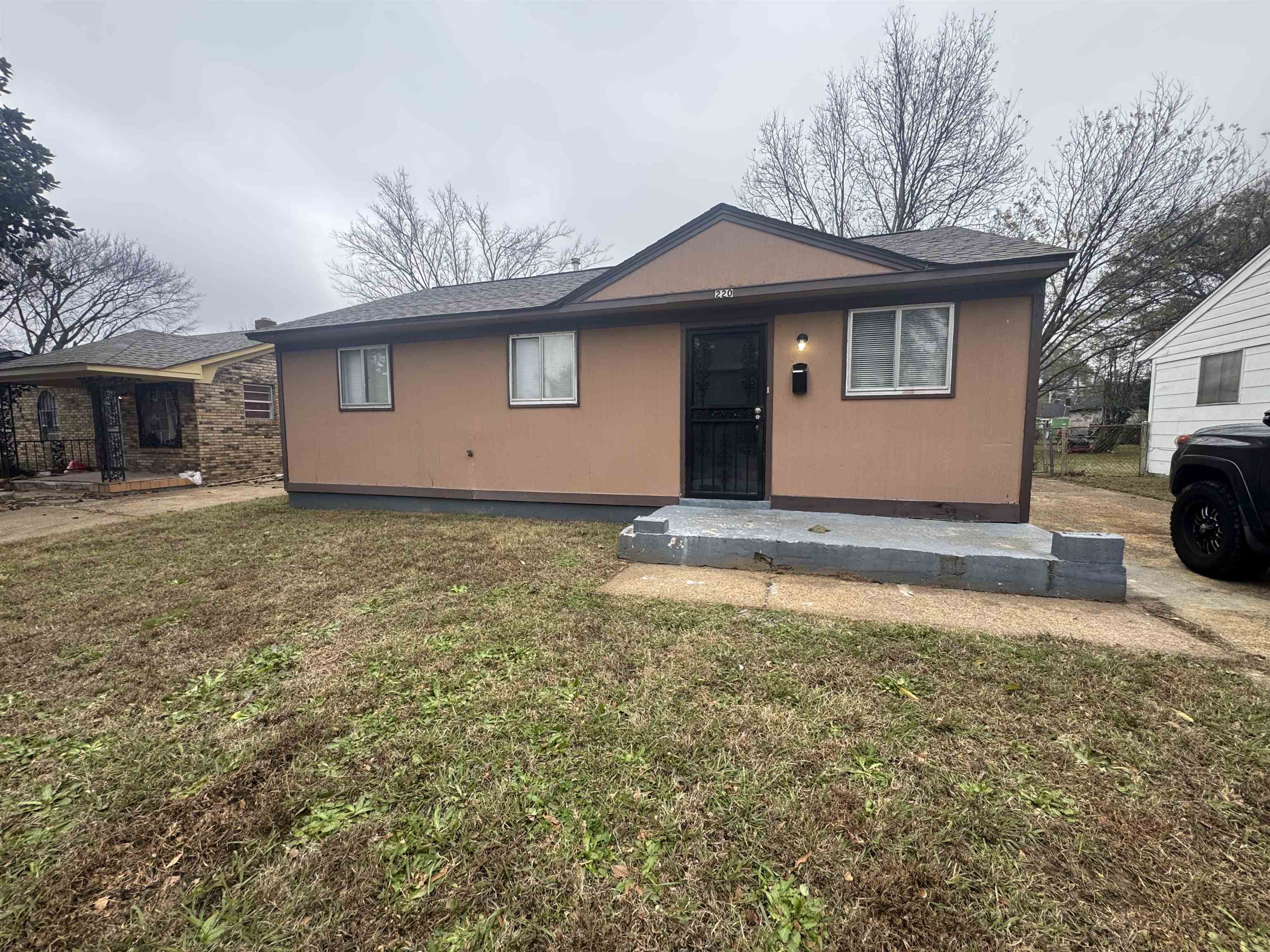 View of front of property with a front yard and a shingled roof