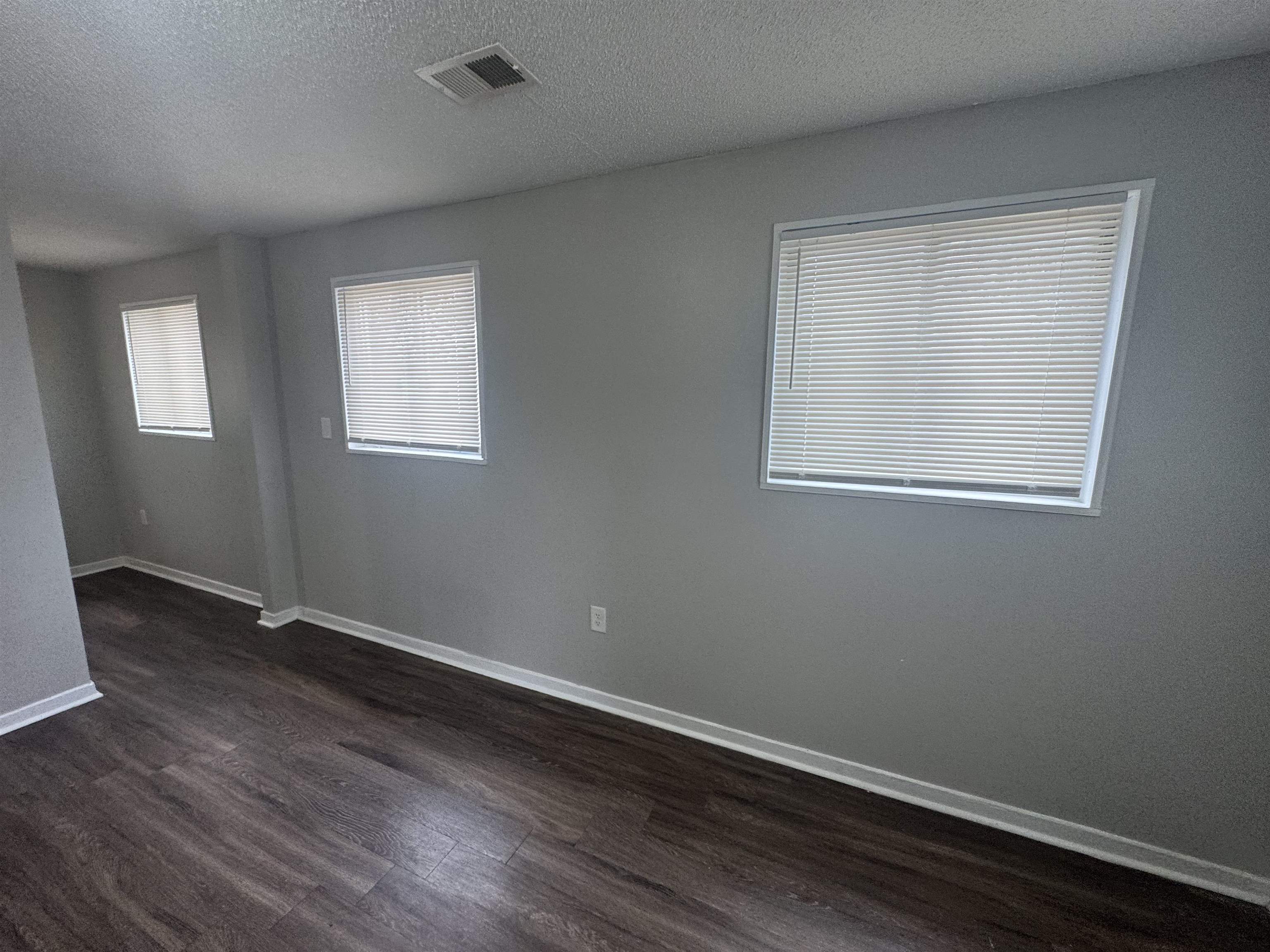 220 Elder Road Memphis, TN 38109 - Photo 2 of 9 Unfurnished room featuring a textured ceiling and dark wood-style flooring