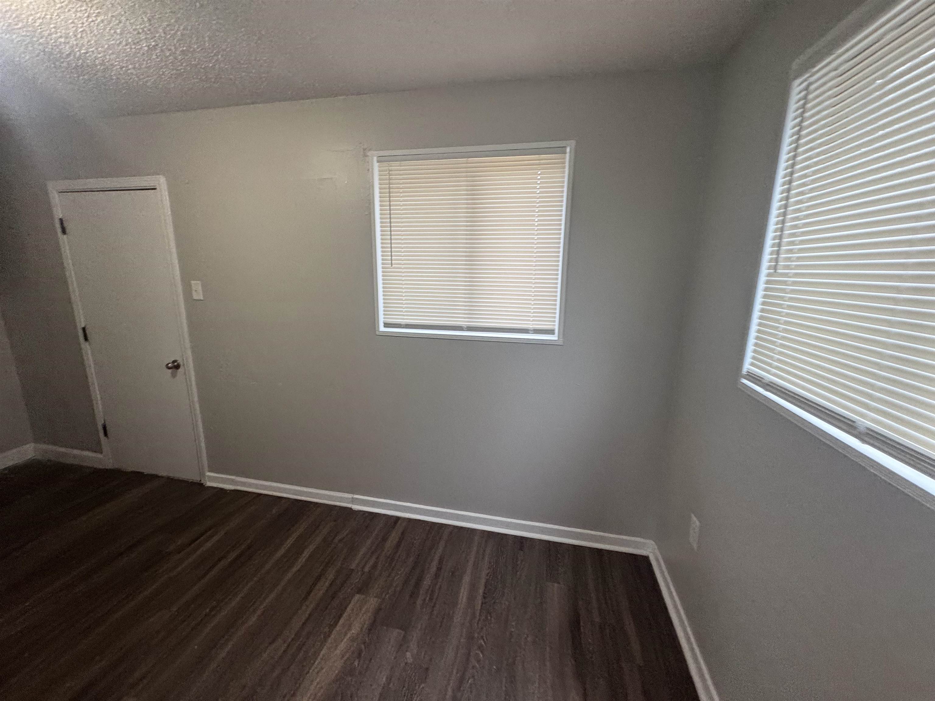 220 Elder Road Memphis, TN 38109 - Photo 4 of 9 Unfurnished room featuring dark wood-style flooring and a textured ceiling