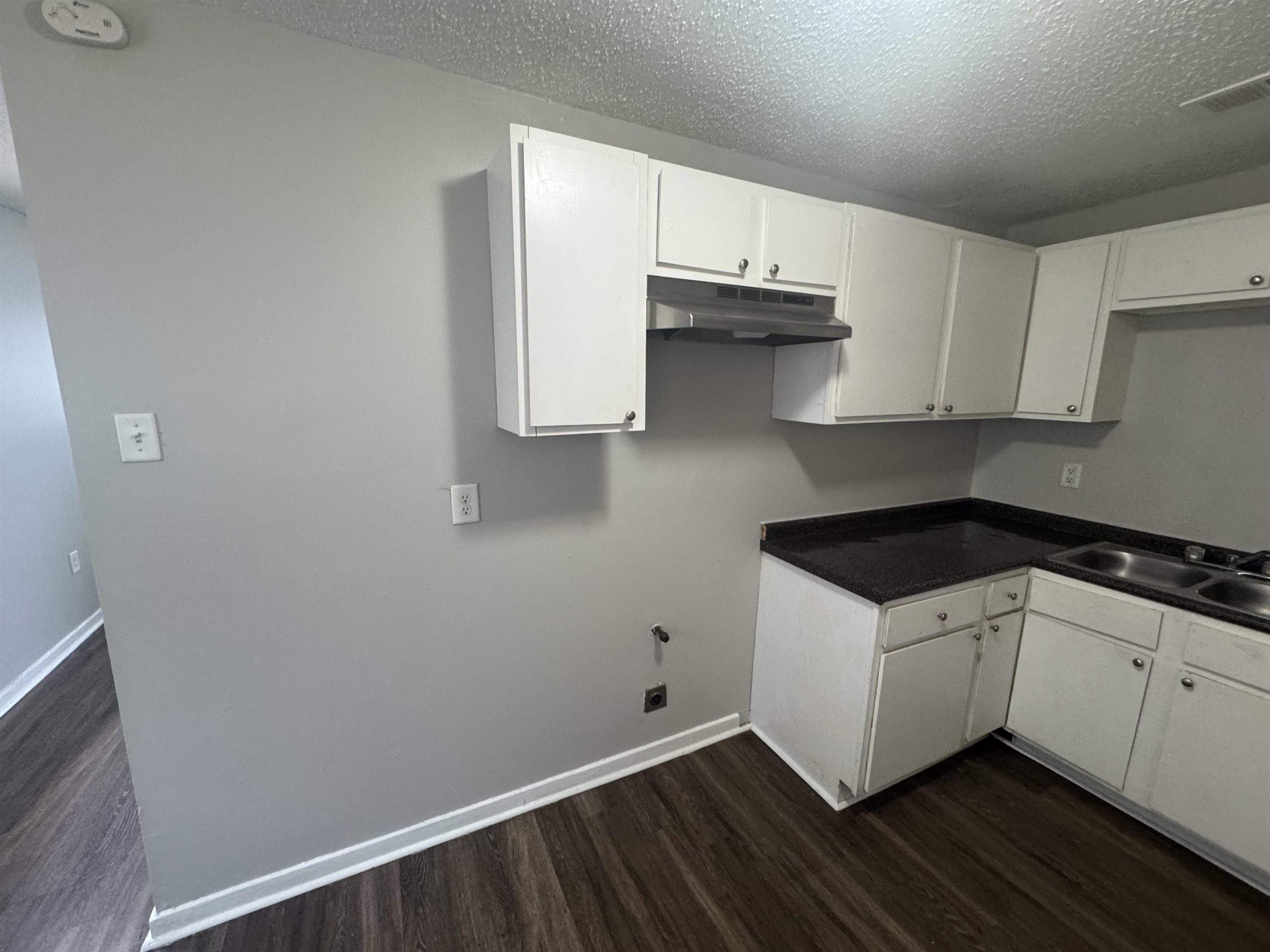 220 Elder Road Memphis, TN 38109 - Photo 6 of 9 Laundry area featuring dark wood-style flooring and a textured ceiling