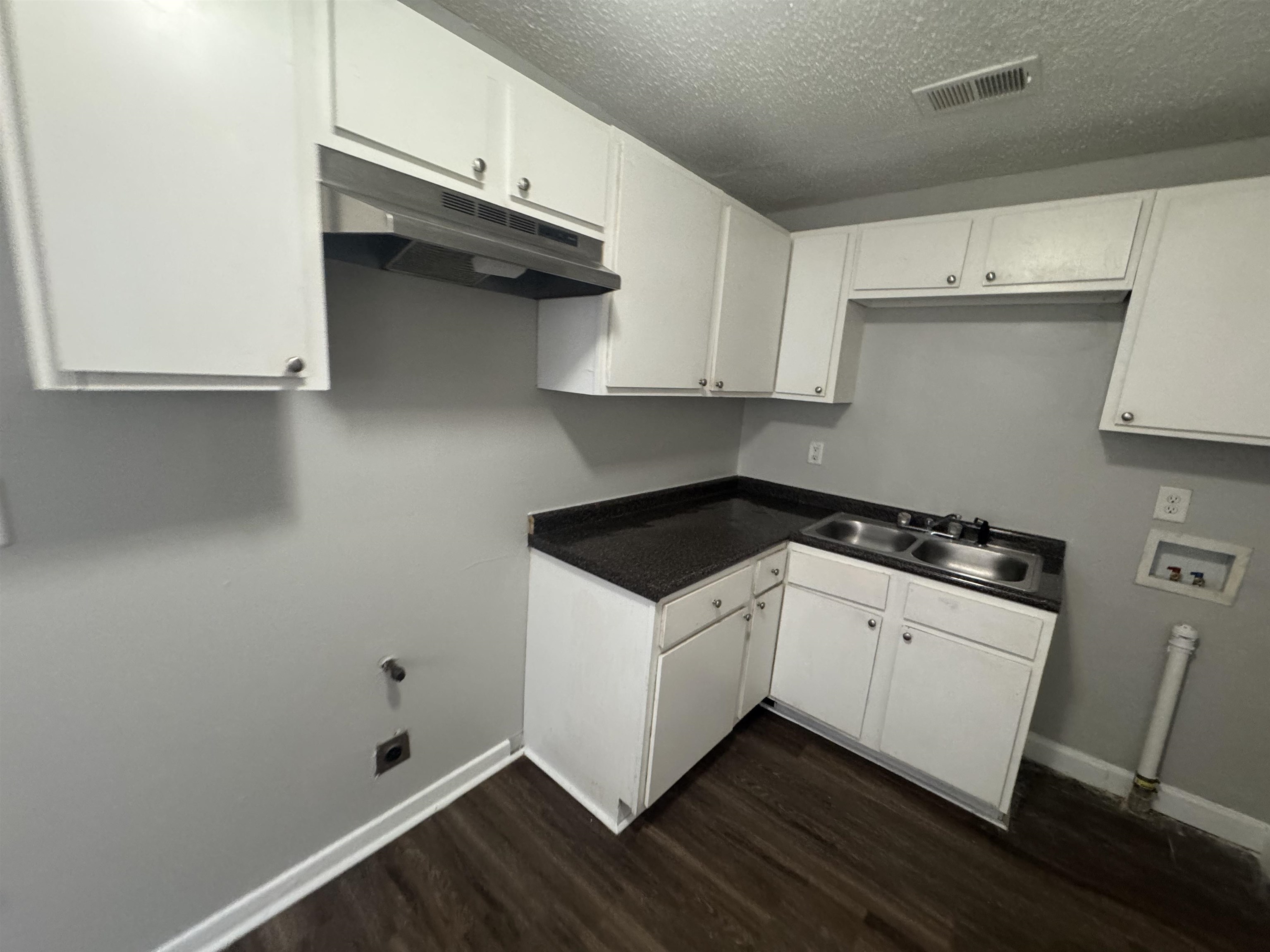 220 Elder Road Memphis, TN 38109 - Photo 7 of 9 Laundry area featuring washer hookup, dark wood-style floors, a textured ceiling, and cabinet space
