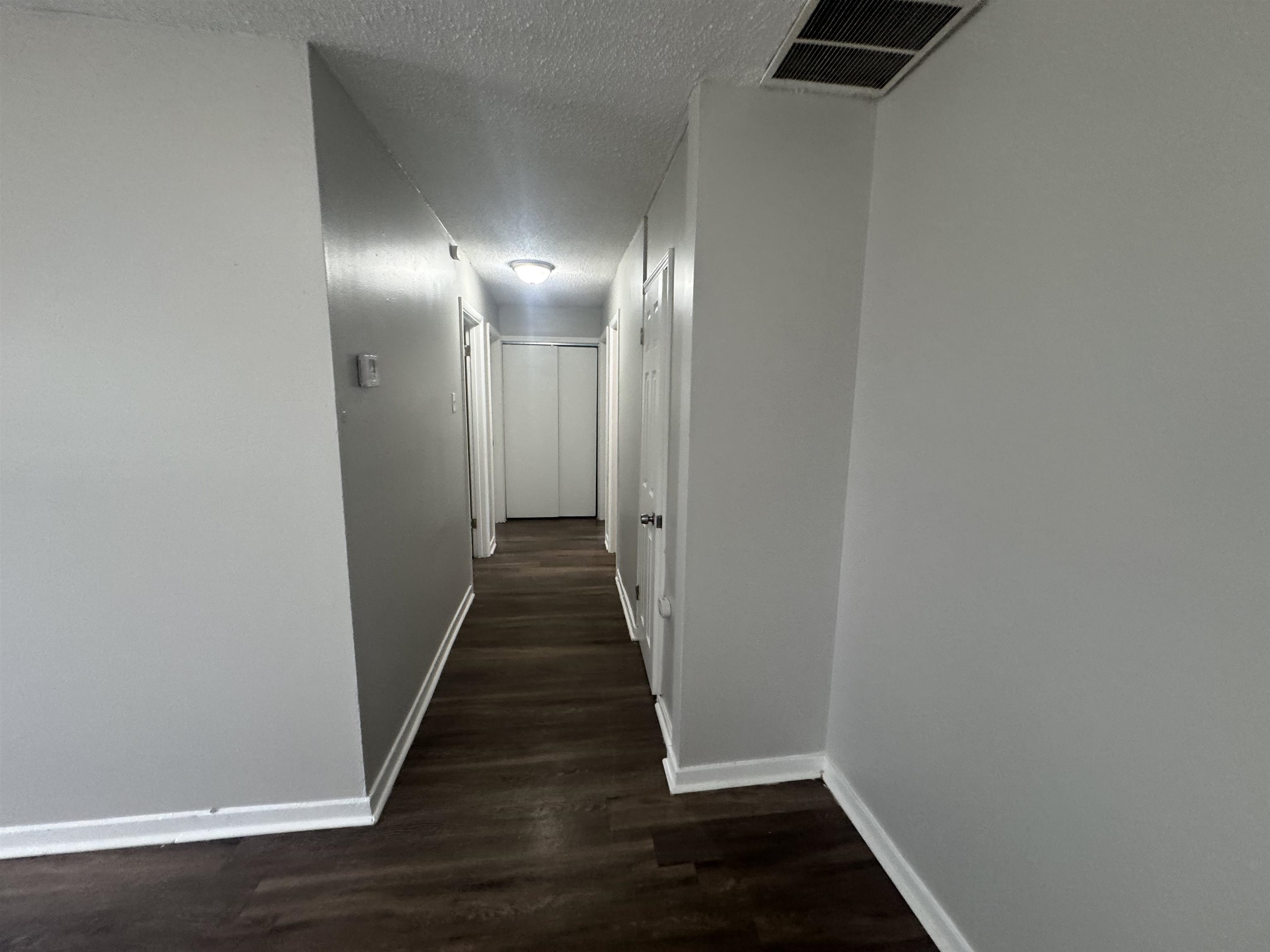 220 Elder Road Memphis, TN 38109 - Photo 8 of 9 Hallway with dark wood-style flooring and a textured ceiling
