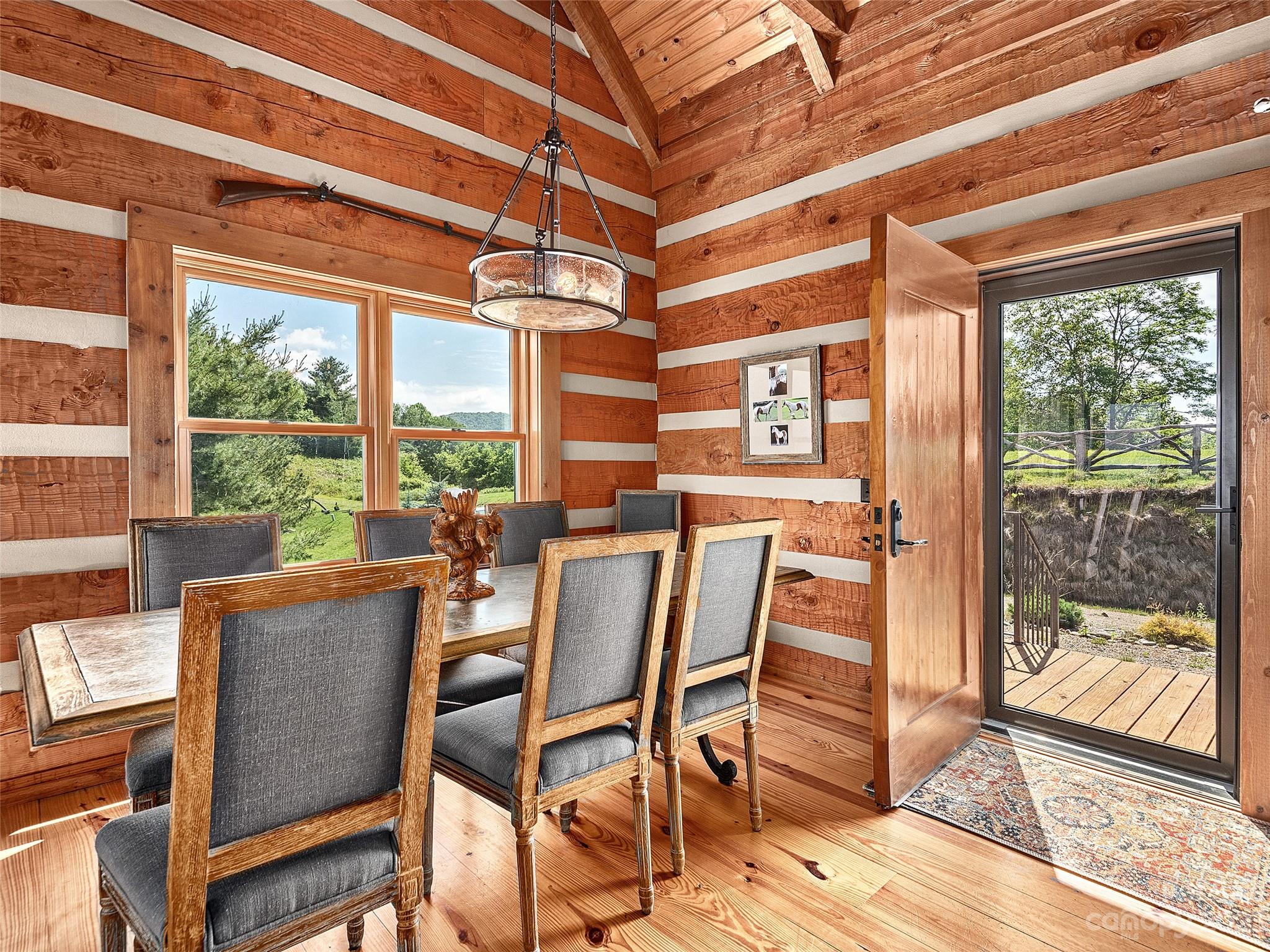 1038 Doggett Gap Road Hot Springs, NC 28743 - Photo 3 of 32 a dining room with furniture a chandelier and wooden floor
