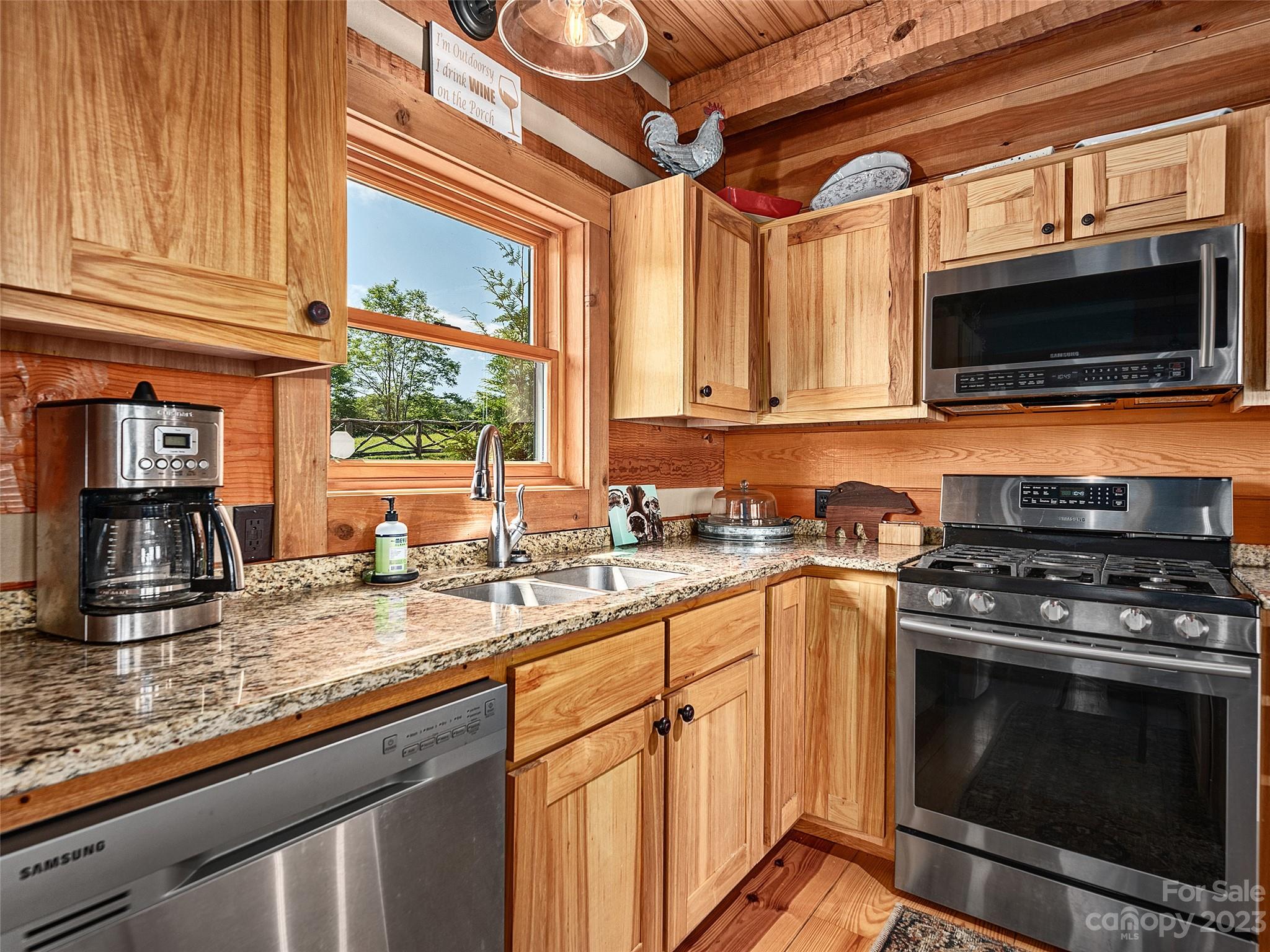 1038 Doggett Gap Road Hot Springs, NC 28743 - Photo 6 of 32 a kitchen with stainless steel appliances granite countertop a stove microwave and sink