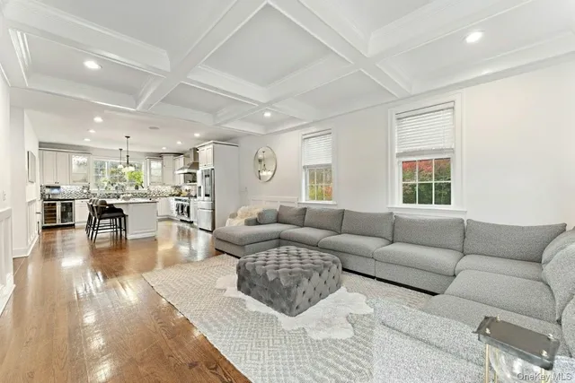 a living room with furniture wooden floor and a large window