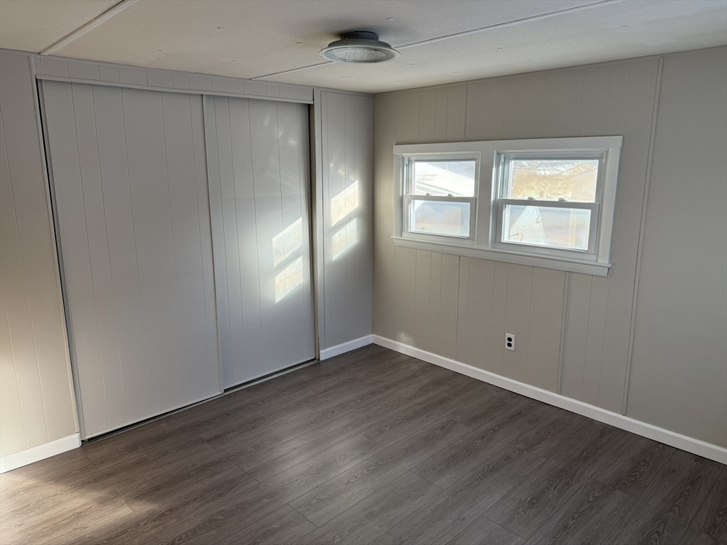281 Chauncey Walker Street, Unit 188 Belchertown, MA 01007 - Photo 14 of 19 an empty room with wooden floor and windows
