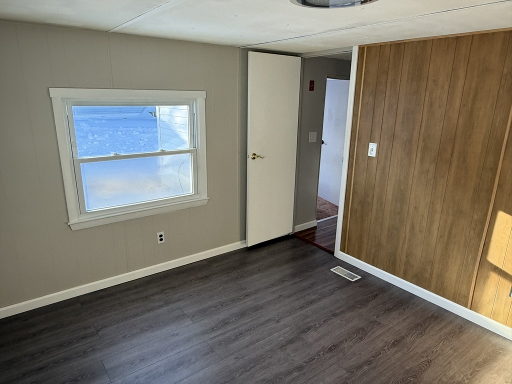 281 Chauncey Walker Street, Unit 188 Belchertown, MA 01007 - Photo 15 of 19 an empty room with wooden floor and a window