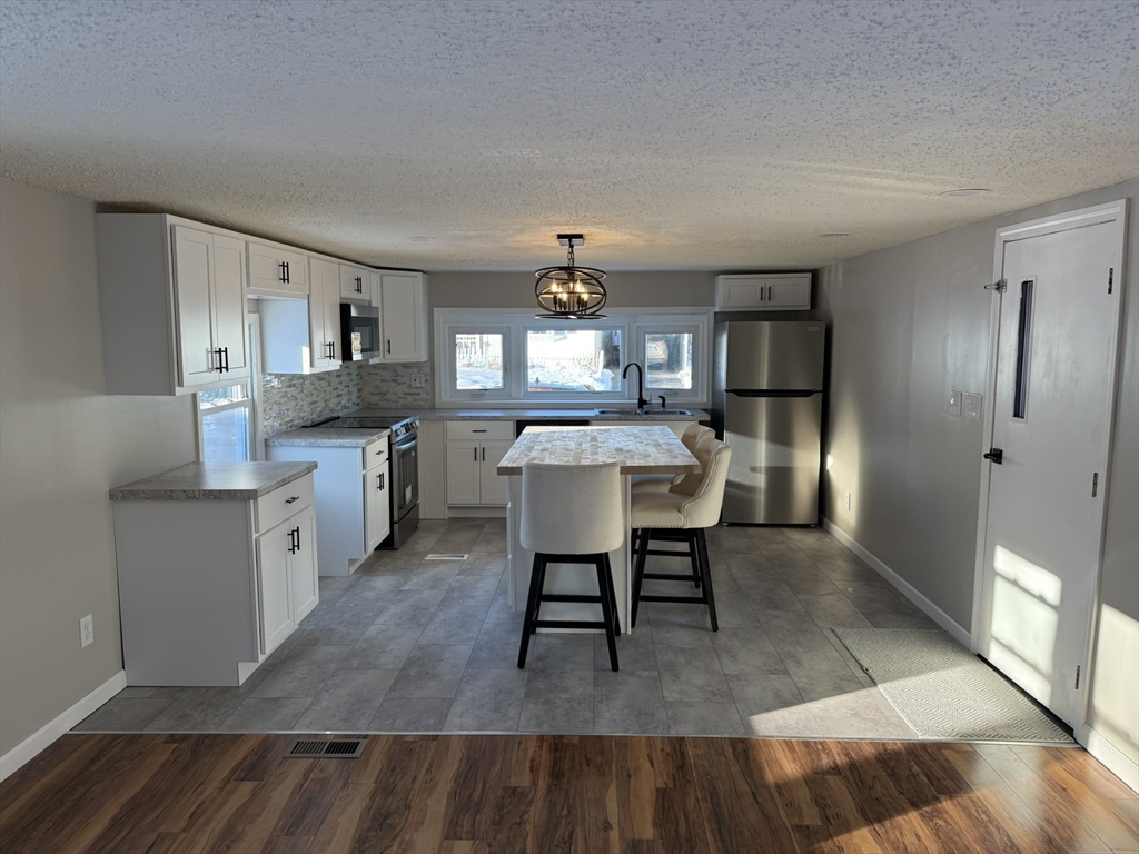 281 Chauncey Walker Street, Unit 188 Belchertown, MA 01007 - Photo 3 of 19 a living room with stainless steel appliances granite countertop furniture wooden floor and a kitchen view