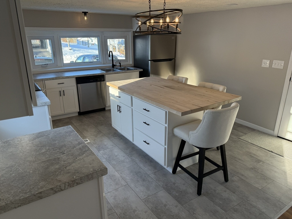 281 Chauncey Walker Street, Unit 188 Belchertown, MA 01007 - Photo 6 of 19 a kitchen with kitchen island a sink stainless steel appliances dining table and chairs