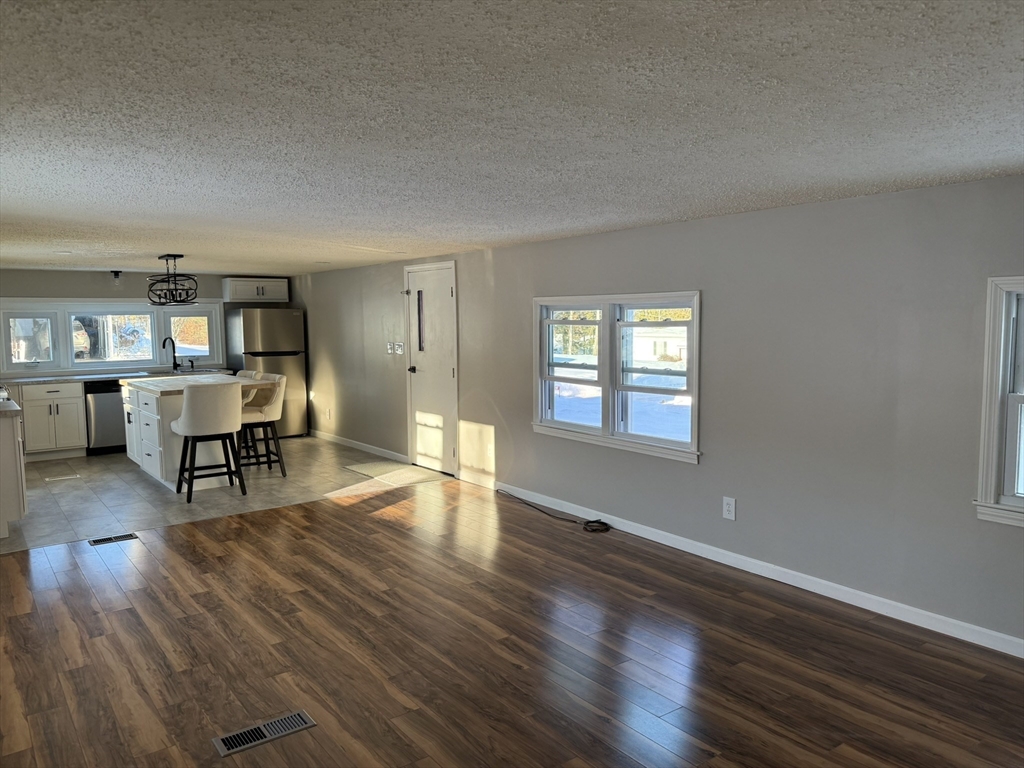 281 Chauncey Walker Street, Unit 188 Belchertown, MA 01007 - Photo 9 of 19 a furnished livingroom with windows and wooden floor