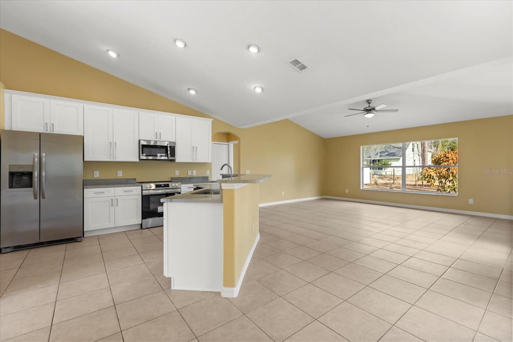 619 Rhodes Drive DeLand, FL 32720 - Photo 21 of 37 a kitchen with stainless steel appliances granite countertop a refrigerator and a stove top oven