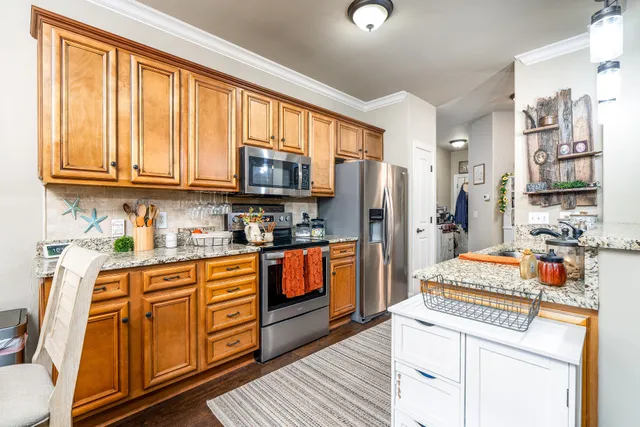 a dining room with stainless steel appliances a table and chairs in it