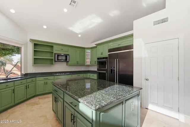 a kitchen with stainless steel appliances granite countertop a sink and a refrigerator