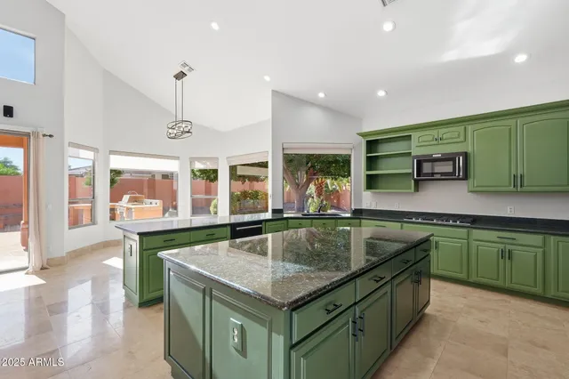 a kitchen with stainless steel appliances granite countertop a sink and a large window
