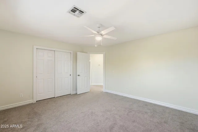 an empty room with a ceiling fan and a window