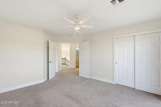 an empty room with a ceiling fan and a window