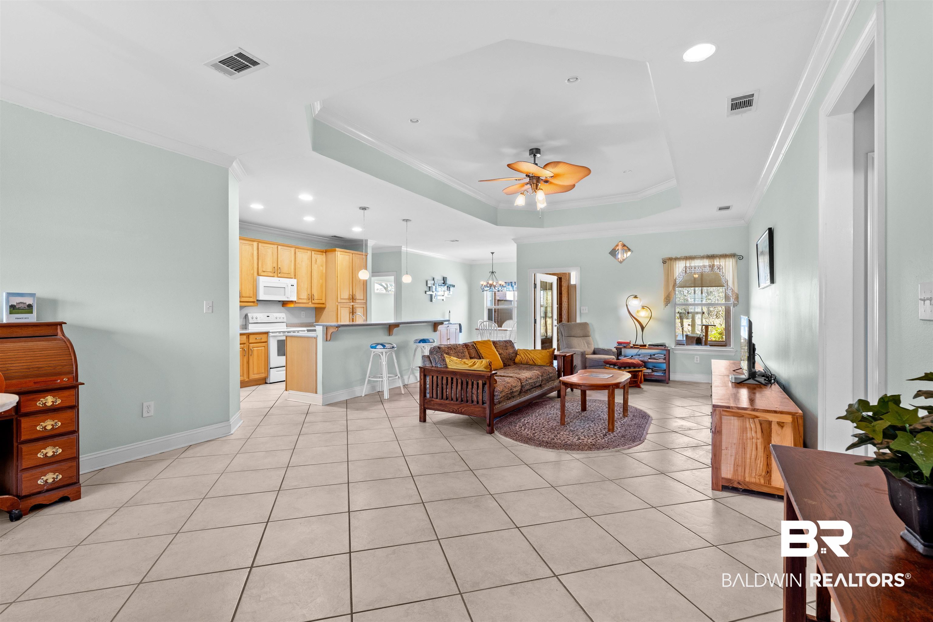 237 Hemingway Loop Foley, AL 36535 - Photo 5 of 49 Living area with ceiling fan with notable chandelier, a raised ceiling, crown molding, and visible vents