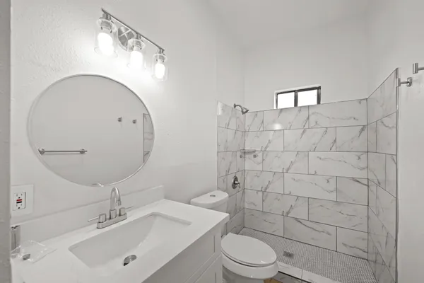 a bathroom with a sink a toilet and shower