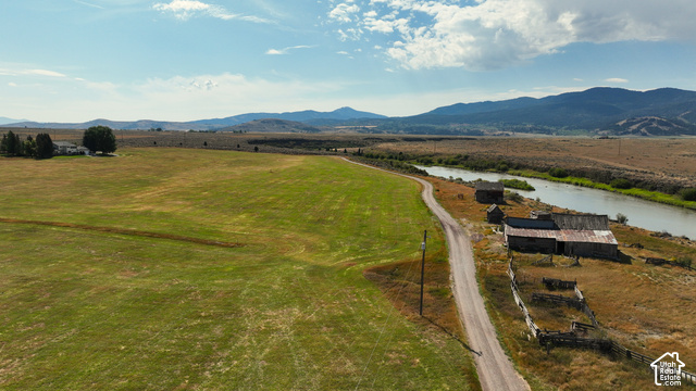 750 South Big Road Soda Springs, ID 83276 - Photo 9 of 40 Expansive green fields, a winding river, distant mountains, and a white residence with a dark roof