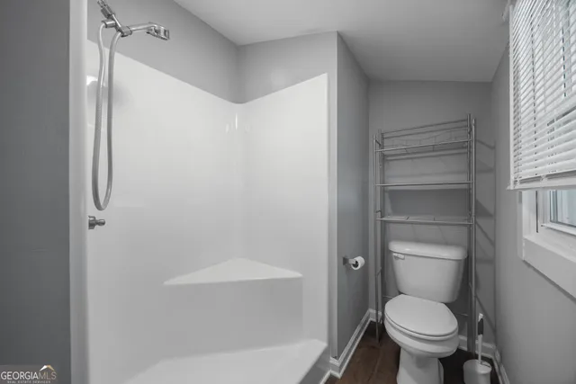 a bathroom with a toilet and a shower