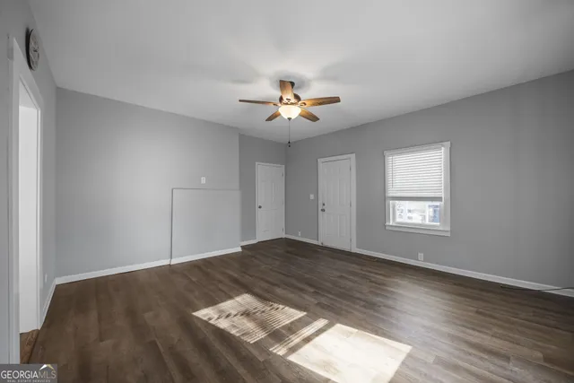 a view of a bedroom with wooden floor and a ceiling fan