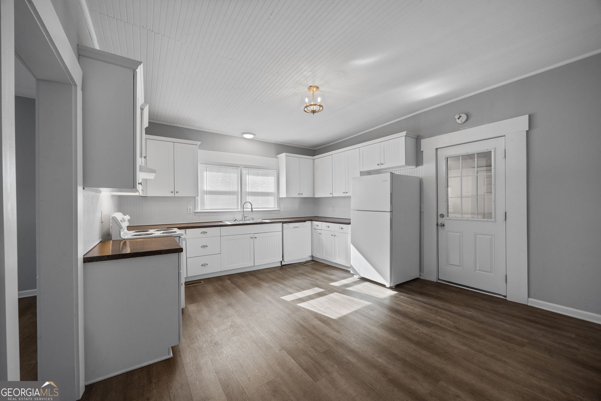 743 Pine Street Trion, GA 30753 - Photo 10 of 31 a kitchen with white cabinets and wooden floor