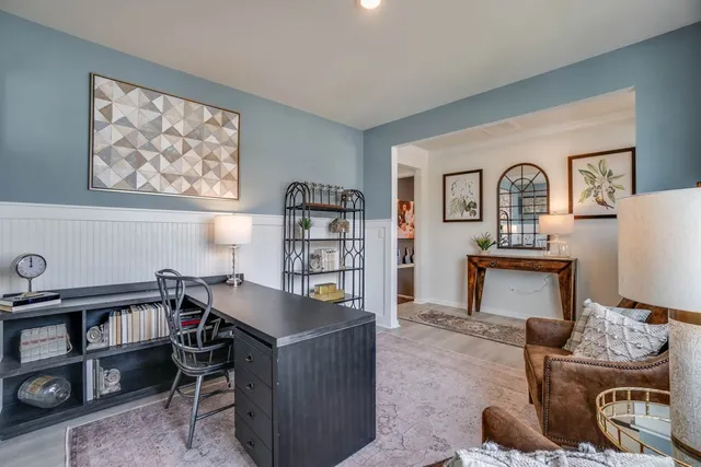 a view of a workspace with furniture and a book shelf