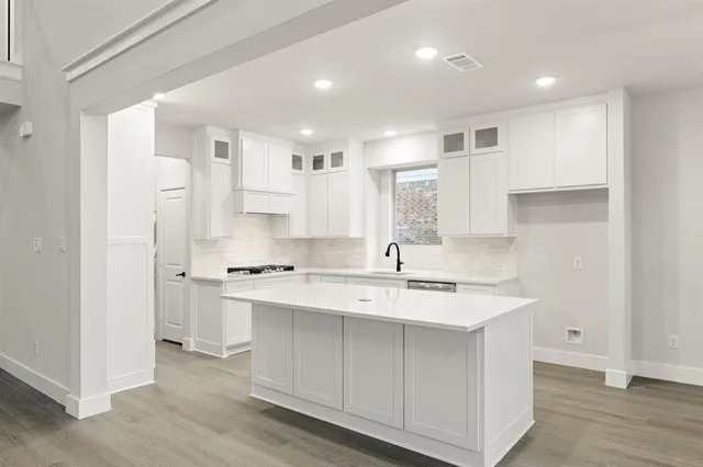 a kitchen with white cabinets sink and stainless steel appliances