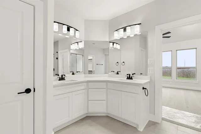 a spacious bathroom with a double vanity sink a mirror and a bathtub