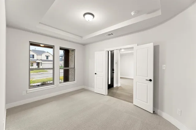 an empty room with windows and closet area