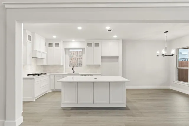 a kitchen with kitchen island a sink stainless steel appliances and cabinets