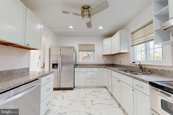 a kitchen with stainless steel appliances granite countertop a sink a stove a refrigerator and island