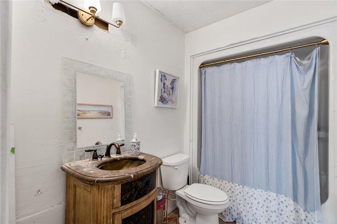 605 Sherry Drive Anderson, SC 29621 - Photo 23 of 36 This bathroom features a single vanity, a toilet, and a shower with a light blue curtain.