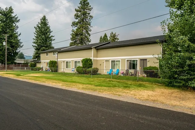 a view of a house with a big yard and large trees