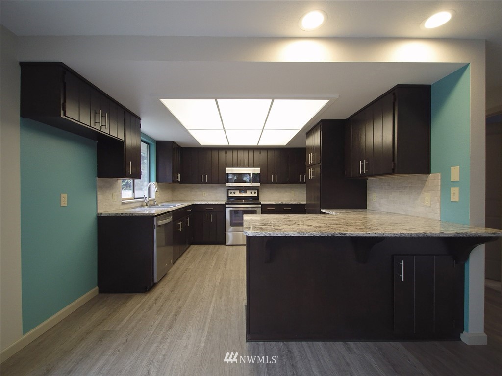 11 Starry Road Sequim, WA 98382 - Photo 8 of 25 a kitchen with stainless steel appliances granite countertop a stove a sink and a refrigerator