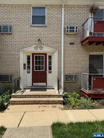 a view of brick house with a small yard and potted plants
