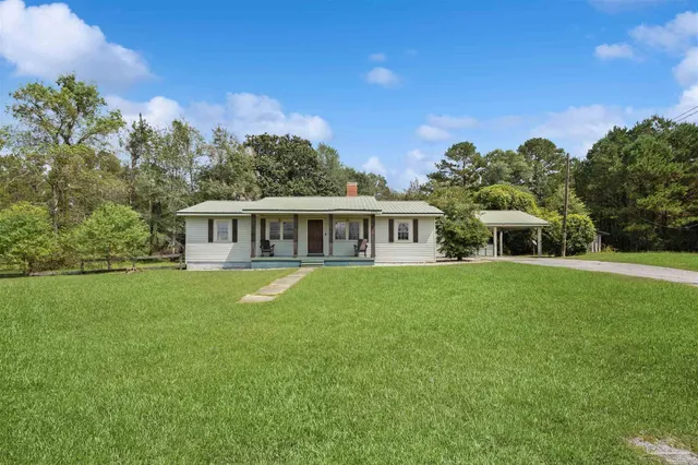 a view of a house with backyard and garden