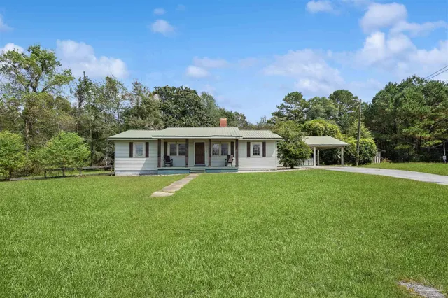 a view of a house with backyard and garden
