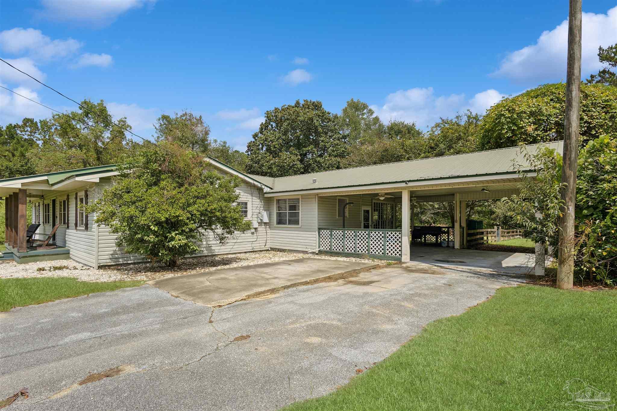 4176 Morristown Road Jay, FL 32565 - Photo 41 of 41 a front view of a house with a garden and trees