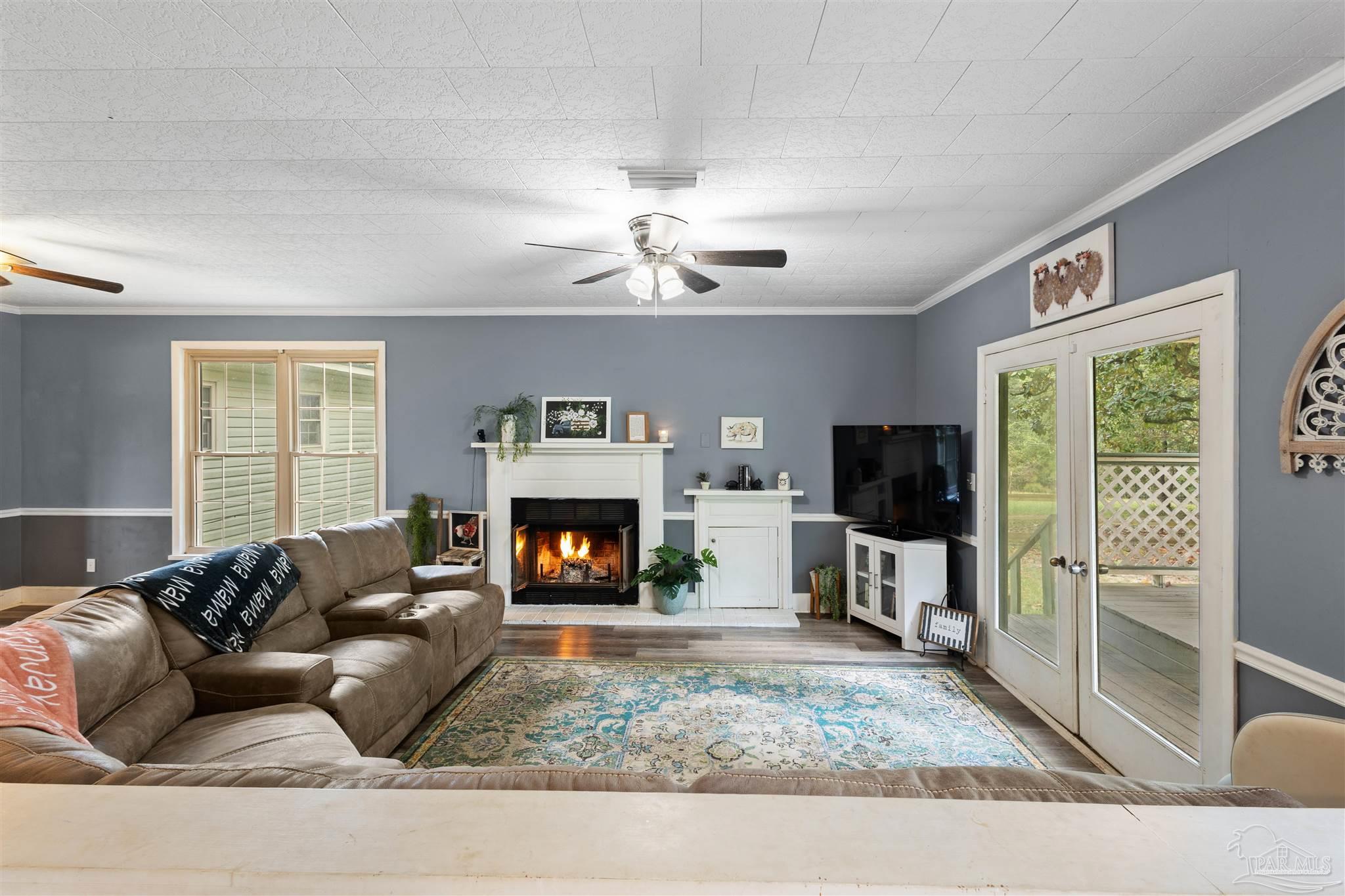 4176 Morristown Road Jay, FL 32565 - Photo 7 of 41 a living room with furniture a flat screen tv and a fireplace