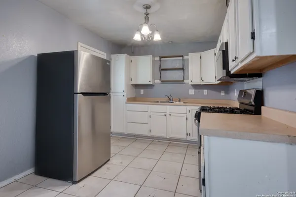a kitchen with a white stove top oven and white cabinets