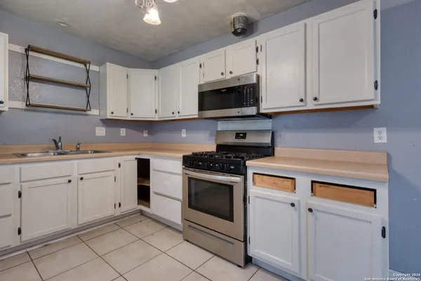 a kitchen with white cabinets and white appliances