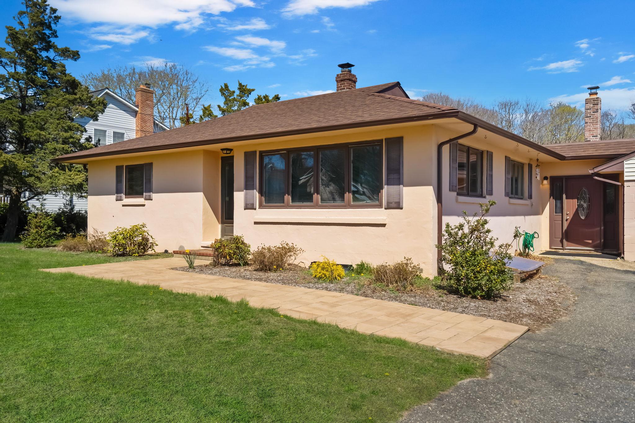 15 Reeves Road Center Moriches, NY 11934 - Photo 1 of 1 View of front of property with a front lawn, a chimney, and stucco siding