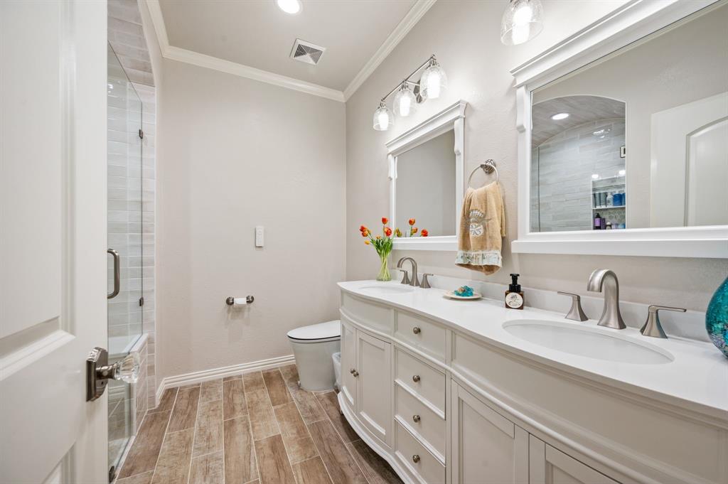 1216 W Road Waxahachie, TX 75165 - Photo 19 of 40 a bathroom with a double vanity sink toilet and shower