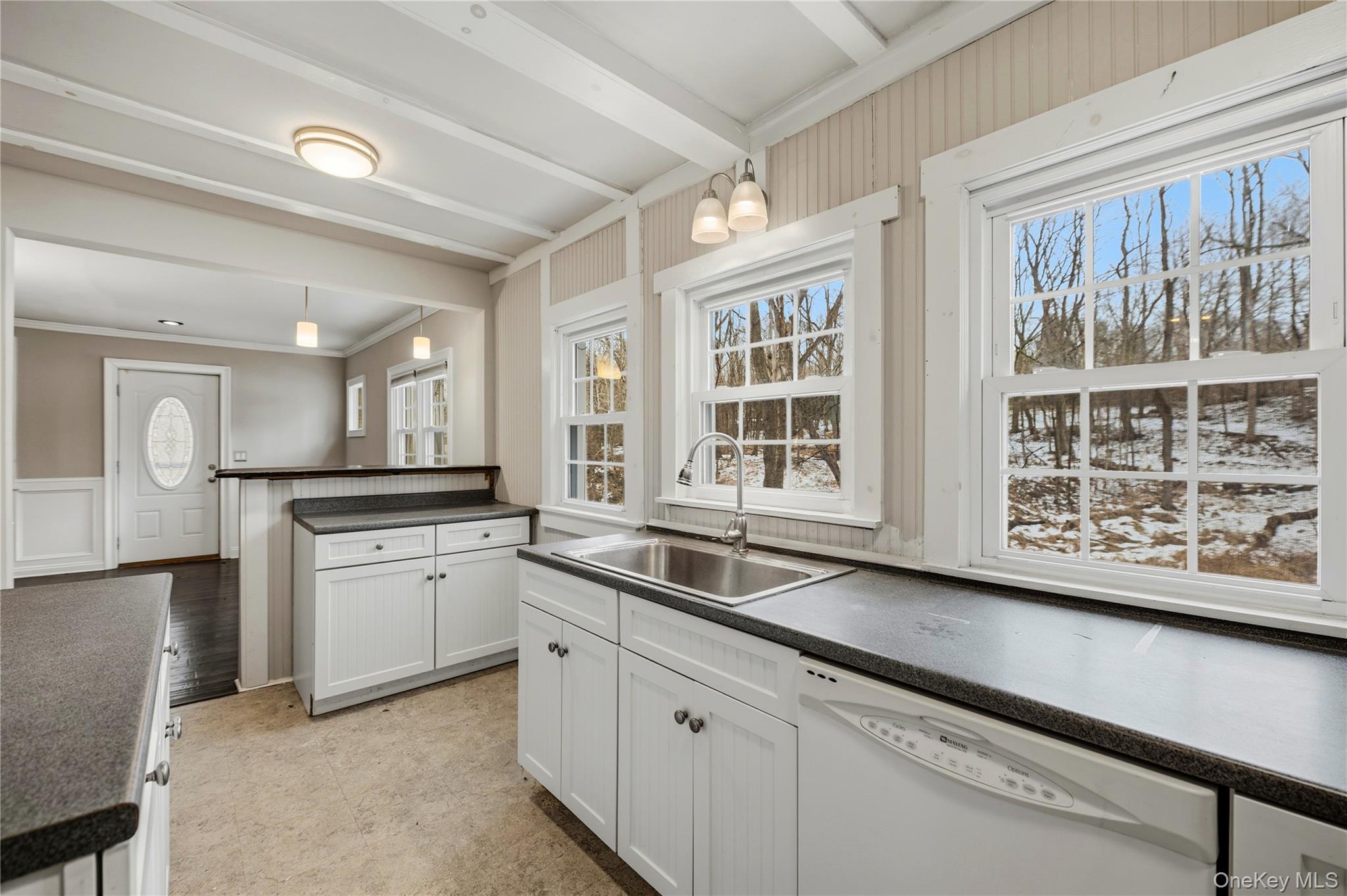 293 Highway 94 Warwick, NY 10990 - Photo 12 of 20 Kitchen featuring white cabinets, dark countertops, white dishwasher, pendant lighting, and a decorative wall