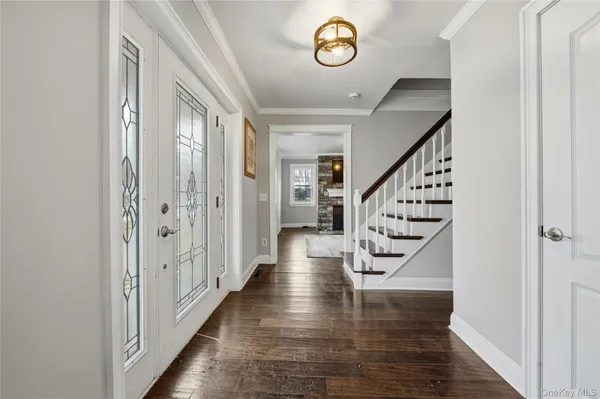a view of entryway and hall with wooden floor